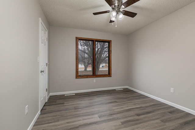 unfurnished room with ceiling fan, dark hardwood / wood-style floors, and a textured ceiling