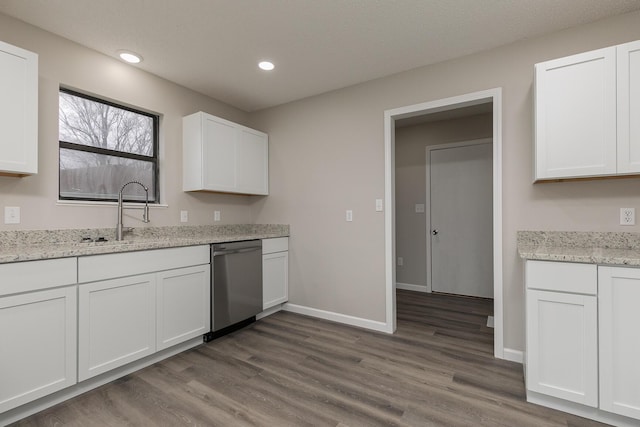 kitchen featuring stainless steel dishwasher, wood-type flooring, white cabinetry, and sink