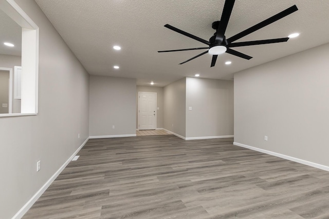 empty room featuring ceiling fan, light hardwood / wood-style floors, and a textured ceiling