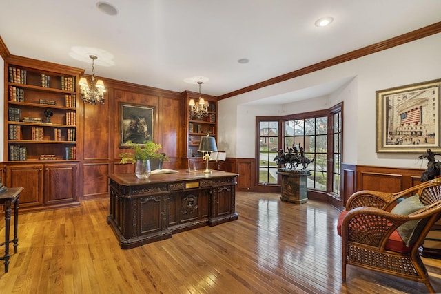 office area featuring built in shelves, crown molding, a chandelier, and light hardwood / wood-style floors