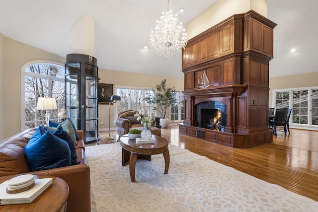 living room featuring light wood-type flooring, a fireplace, and a high ceiling