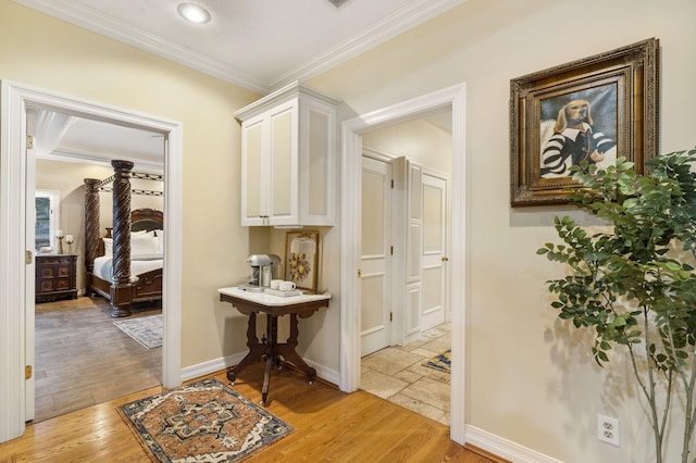 corridor with light wood-type flooring and crown molding