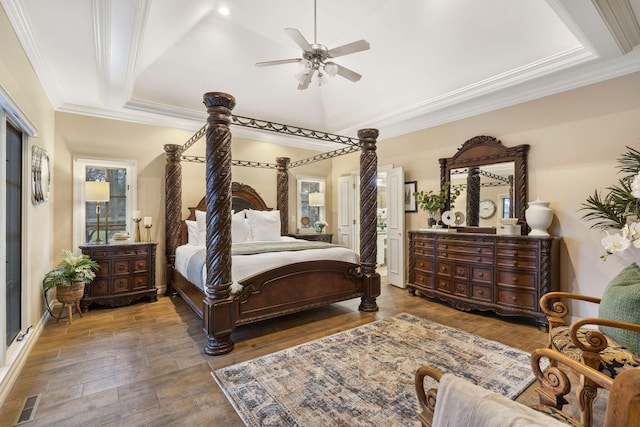 bedroom with dark hardwood / wood-style flooring, a raised ceiling, ceiling fan, and crown molding