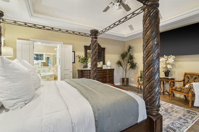 bedroom with a raised ceiling, ceiling fan, crown molding, hardwood / wood-style floors, and connected bathroom