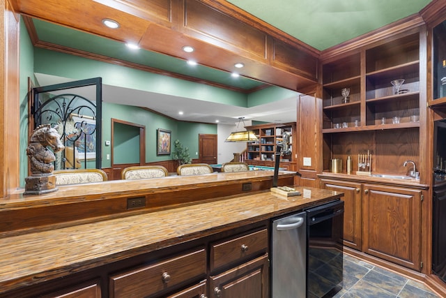 kitchen featuring wood counters, dishwasher, sink, hanging light fixtures, and dark brown cabinets