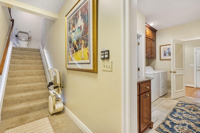 washroom featuring cabinets, a textured ceiling, and washing machine and dryer