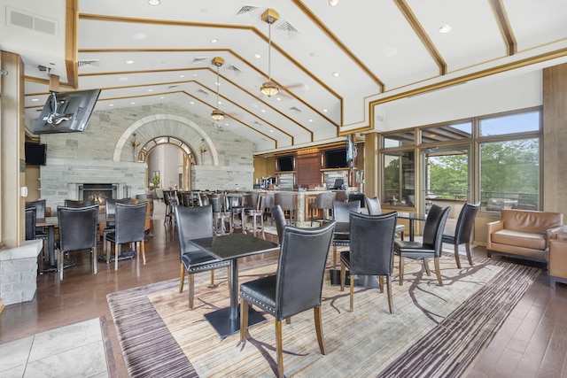 dining room featuring high vaulted ceiling and wood-type flooring