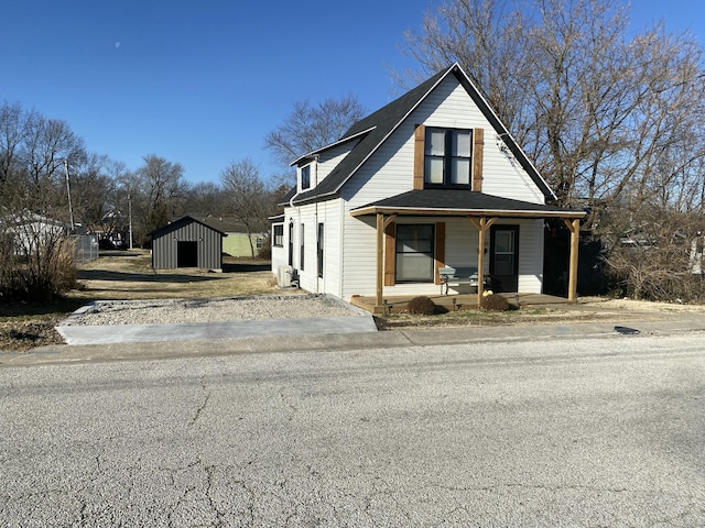 view of front of property featuring covered porch and a storage shed