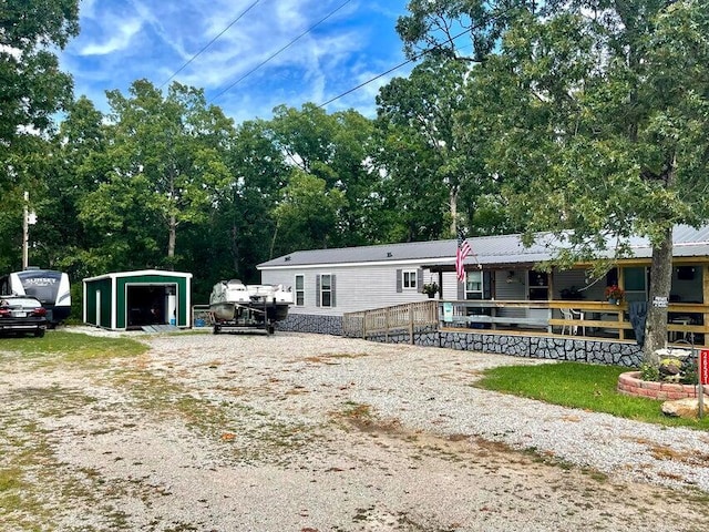 manufactured / mobile home featuring an outbuilding, a porch, and a garage