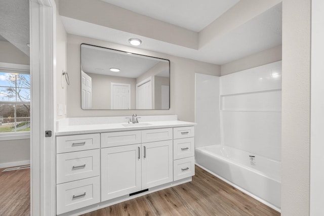 bathroom with shower / bathing tub combination, vanity, and wood-type flooring