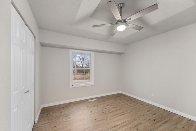 unfurnished bedroom featuring ceiling fan, a closet, and light wood-type flooring