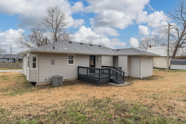 rear view of house featuring central AC unit, a deck, and a yard