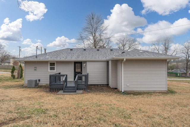 rear view of house featuring a deck, a yard, and central AC