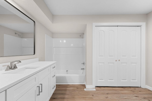 bathroom with vanity, wood-type flooring, and shower / washtub combination