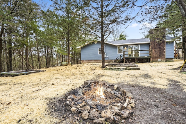 exterior space featuring an outdoor fire pit and a wooden deck