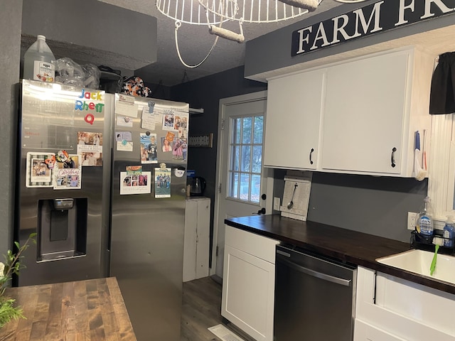 kitchen featuring butcher block counters, white cabinetry, stainless steel fridge with ice dispenser, dark hardwood / wood-style floors, and dishwasher