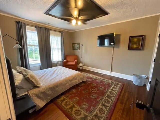 bedroom with a textured ceiling, dark hardwood / wood-style floors, ceiling fan, and crown molding