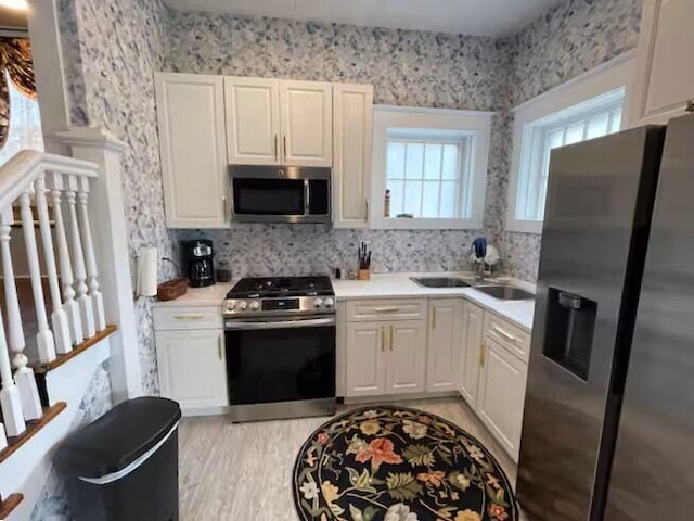 kitchen featuring white cabinets, sink, and stainless steel appliances