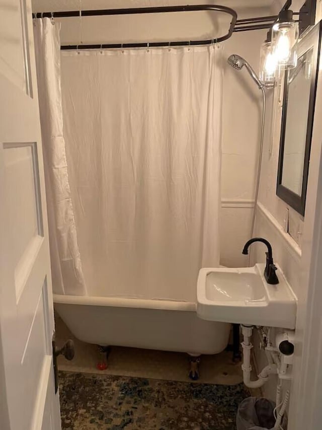 bathroom with shower / bathtub combination with curtain and sink