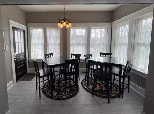 dining room featuring a healthy amount of sunlight and an inviting chandelier