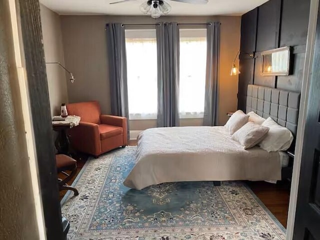 bedroom with hardwood / wood-style flooring, ceiling fan, and multiple windows