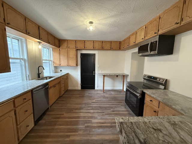 kitchen with dark hardwood / wood-style floors, sink, stainless steel appliances, and a textured ceiling