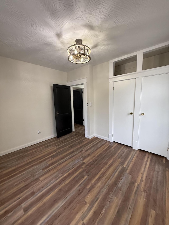 unfurnished bedroom featuring a textured ceiling and dark wood-type flooring