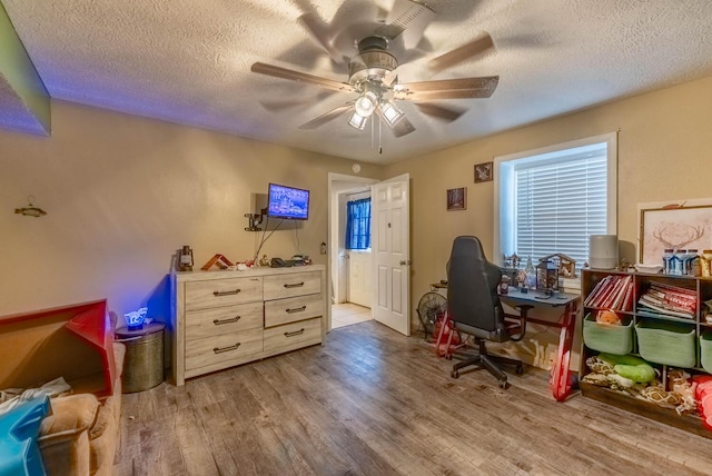 office area featuring wood-type flooring, a textured ceiling, and ceiling fan