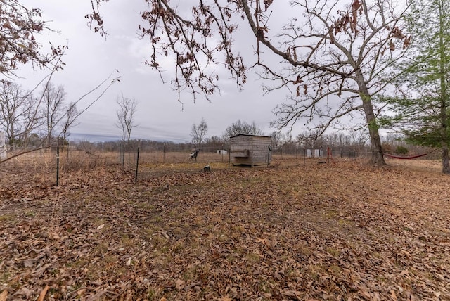 view of yard featuring a rural view and a storage shed