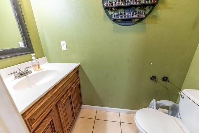 bathroom with toilet, vanity, and tile patterned floors