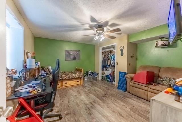 interior space featuring hardwood / wood-style floors, a textured ceiling, and ceiling fan