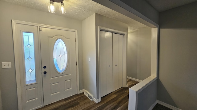 entrance foyer with a textured ceiling and dark hardwood / wood-style floors