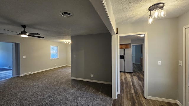 carpeted empty room featuring ceiling fan and a textured ceiling