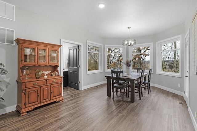 dining room featuring a wealth of natural light, dark hardwood / wood-style floors, and a notable chandelier