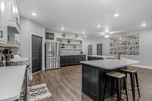 1369 E 398th Rd, Bolivar, MO 65613 - kitchen with stainless steel fridge, ceiling fan, electric range oven, a center island with sink, and light countertops