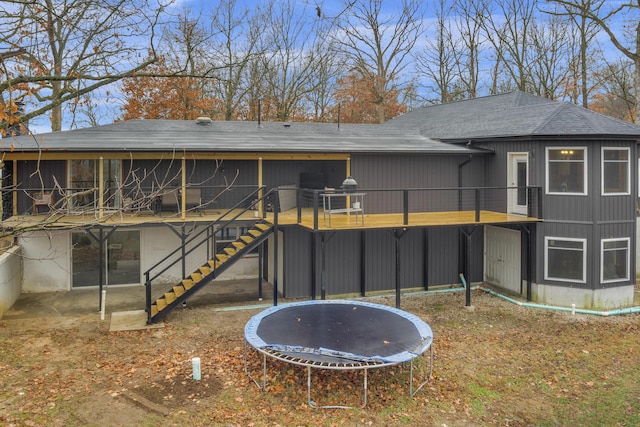 1369 E 398th Rd, Bolivar, MO 65613 - back of property featuring a trampoline, stairs, a shingled roof, and a wooden deck
