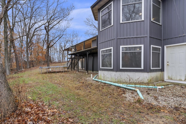 view of side of property with a deck and a trampoline