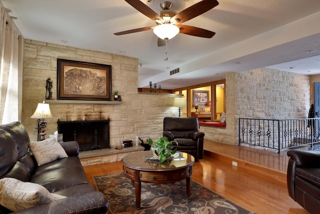 living room with a fireplace, hardwood / wood-style flooring, and ceiling fan