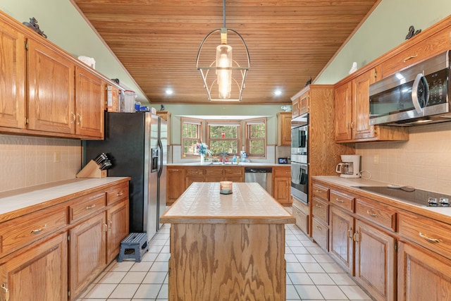 kitchen with stainless steel appliances, lofted ceiling, decorative light fixtures, decorative backsplash, and a kitchen island