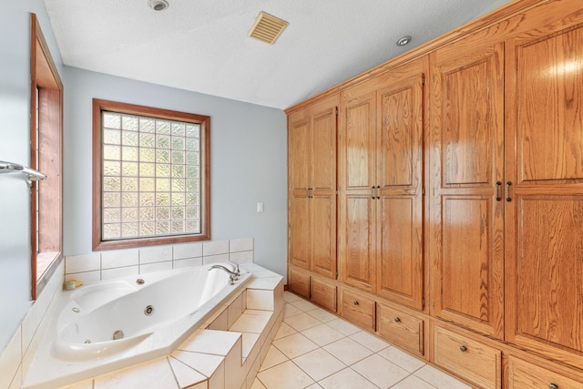 bathroom with tile patterned flooring, a textured ceiling, and tiled tub