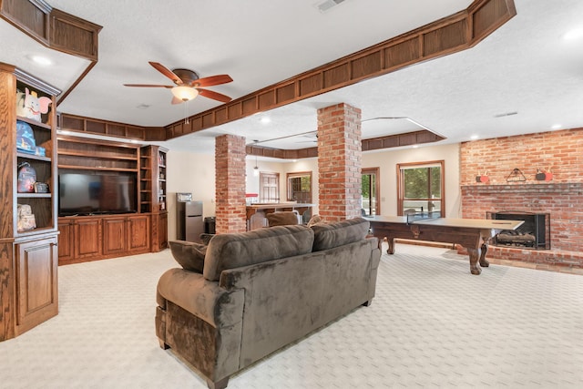 living room with decorative columns, light carpet, a fireplace, and ceiling fan