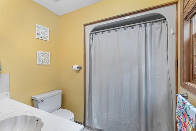 bathroom with vanity, a textured ceiling, and toilet