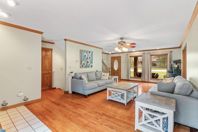 living room featuring wood-type flooring, ceiling fan, and ornamental molding