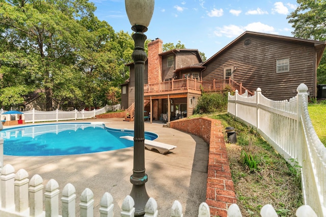 view of pool featuring a patio and a wooden deck