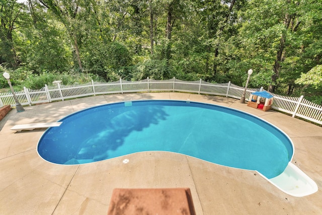 view of swimming pool with a diving board