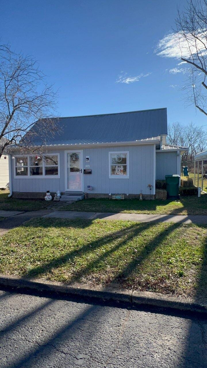 single story home featuring a front lawn