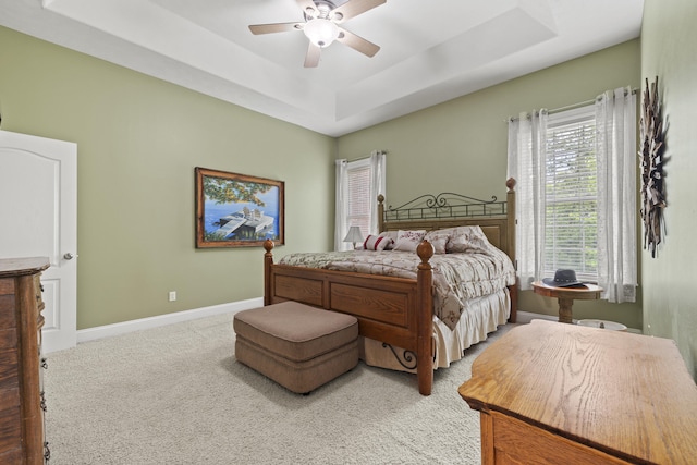 bedroom featuring carpet flooring, ceiling fan, and a raised ceiling