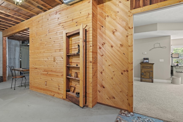 corridor featuring wood walls and concrete floors