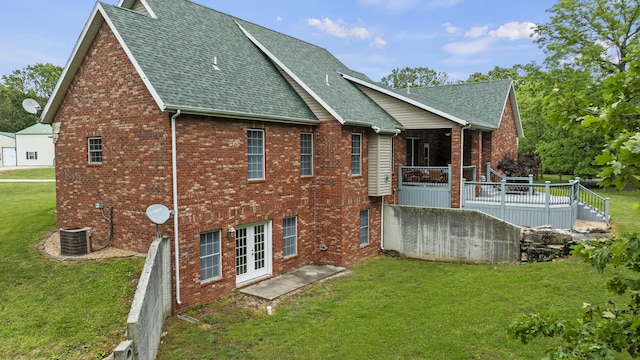 rear view of house featuring central AC unit, a yard, and a wooden deck