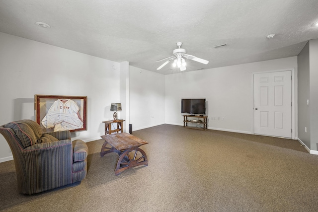 living area featuring ceiling fan, a textured ceiling, and dark colored carpet